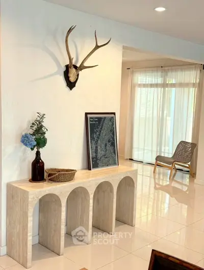 Stylish living room with modern decor and natural light, featuring unique wall art and elegant furniture.