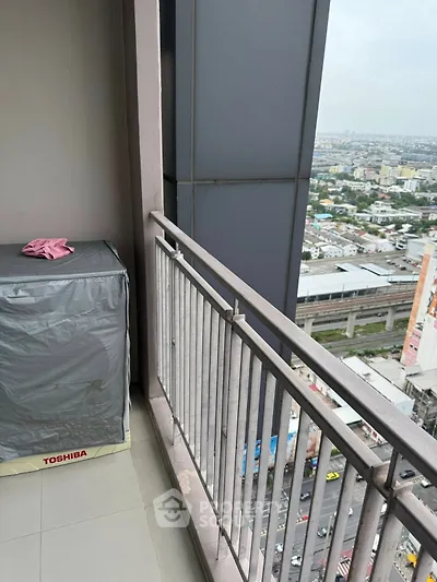 High-rise balcony with city view and covered appliance, ideal for urban living.