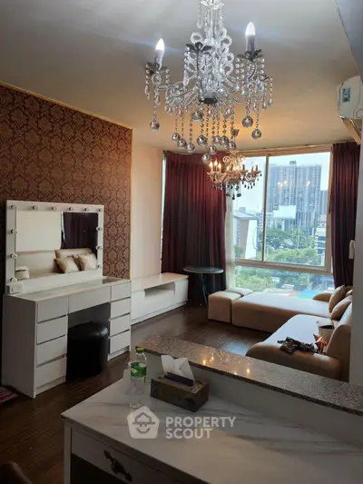 Luxurious living room with chandelier and city view, featuring elegant decor and comfortable seating.