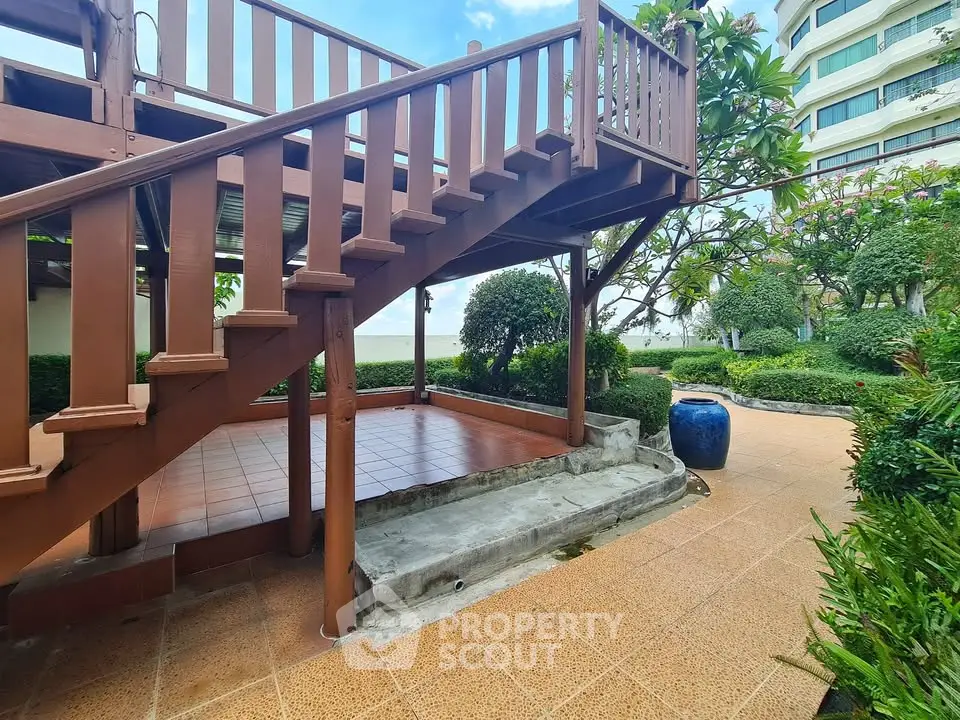 Charming outdoor garden area with wooden staircase and lush greenery, perfect for relaxation and leisure.