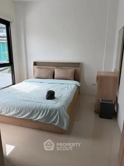 Cozy bedroom with natural light and modern furnishings, perfect for relaxation.