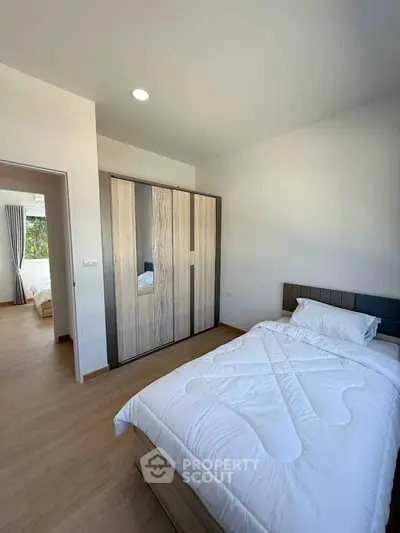 Modern bedroom with wooden flooring and sleek wardrobe design