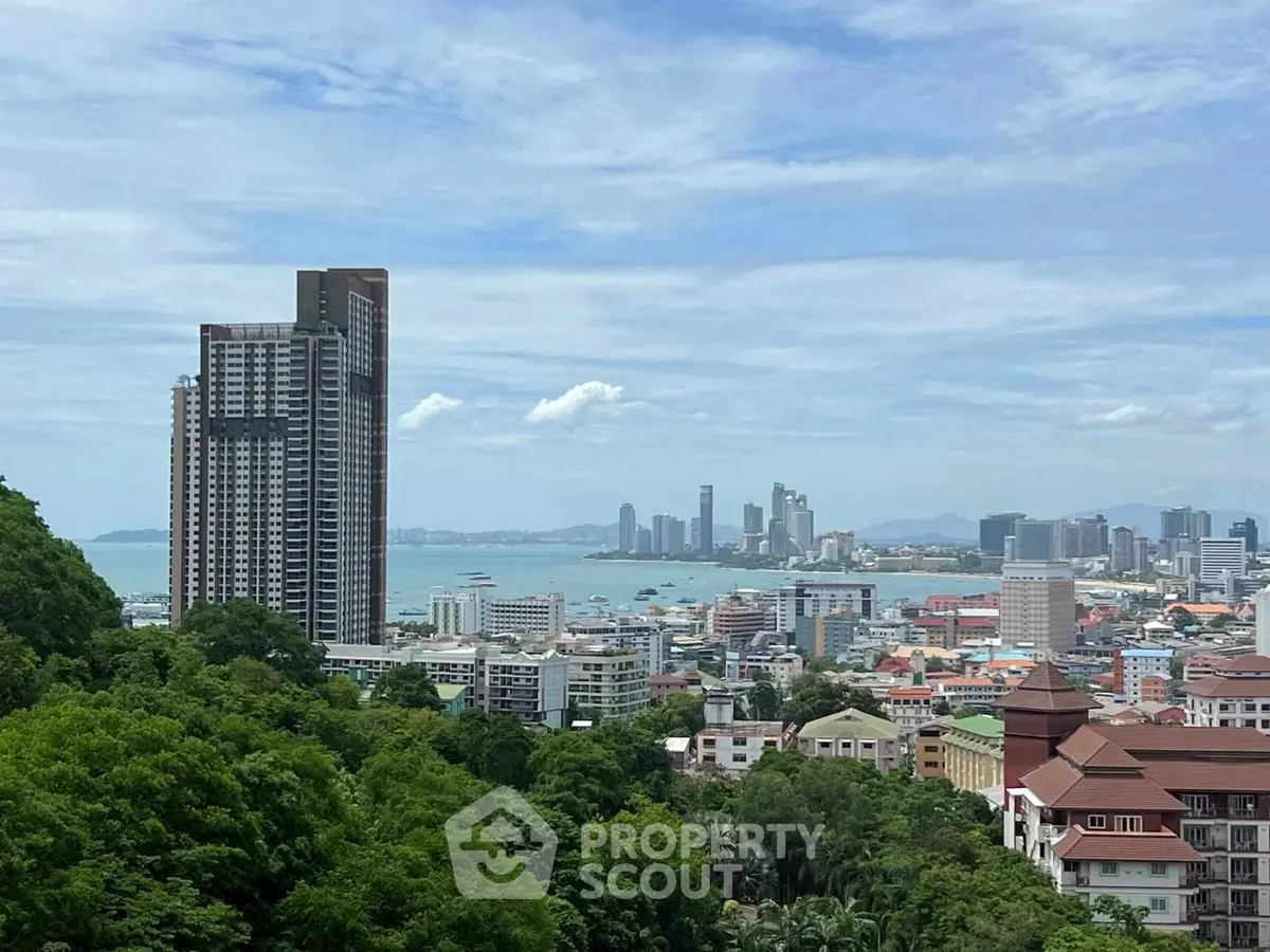 Stunning cityscape view with lush greenery and ocean backdrop, showcasing urban living at its finest.