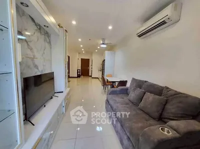 Modern living room with sleek design, featuring a plush sofa, wall-mounted TV, and elegant marble accents.
