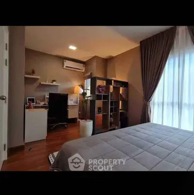 Modern bedroom with study area, featuring sleek furniture and large window with elegant curtains.