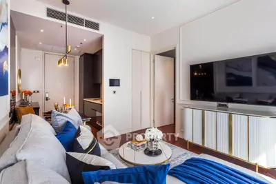 Luxurious living room with modern decor and large TV, perfect for relaxation and entertainment.