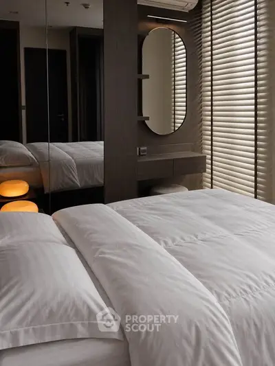 Luxurious modern bedroom with elegant decor and soft lighting, featuring a stylish mirror and cozy bedding.