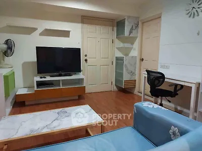 Modern living room with stylish furniture and entertainment setup in cozy apartment.