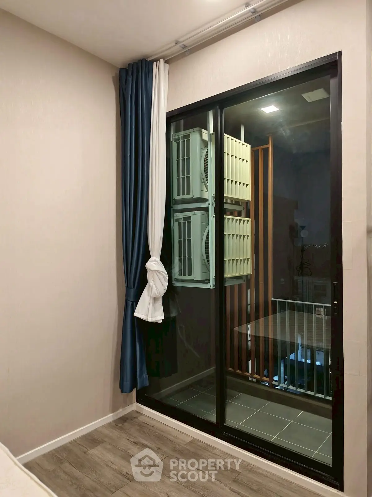 Modern bedroom with balcony view and air conditioning units