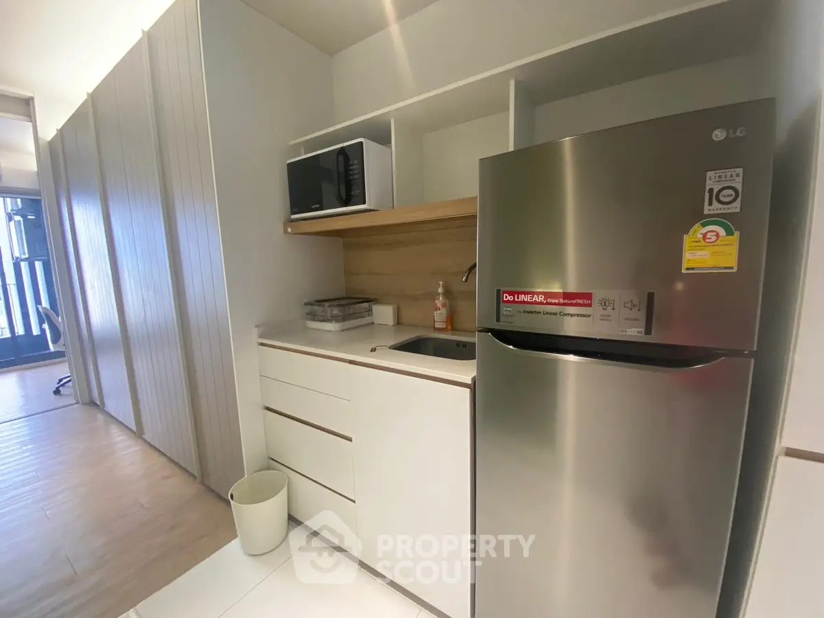 Modern kitchen with sleek appliances and minimalist design in compact space.