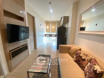 Modern living room with stylish decor and open layout, featuring a cozy sofa and wall-mounted TV.