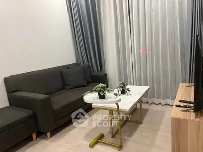 Modern living room with sleek sofa, stylish coffee table, and elegant curtains.