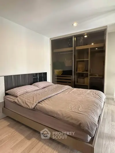 Modern bedroom with sleek wardrobe and cozy bedding in a stylish apartment.