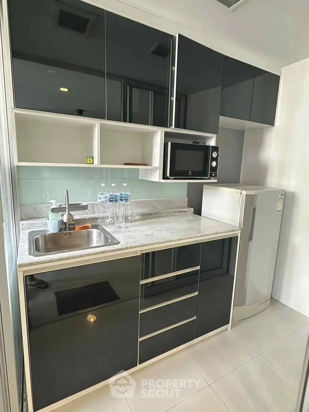 Modern kitchen with sleek black cabinets and marble countertop