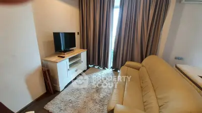 Cozy living room with plush sofa and TV, perfect for relaxation.
