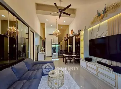 Luxurious living room with high ceilings, elegant chandelier, and modern decor