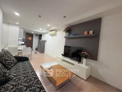Modern living room with stylish decor and open layout, featuring a cozy sofa and entertainment center.