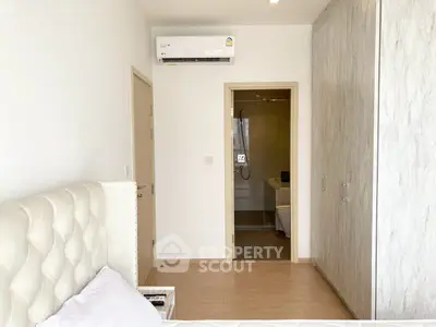 Modern bedroom with ensuite bathroom and air conditioning in a stylish apartment.