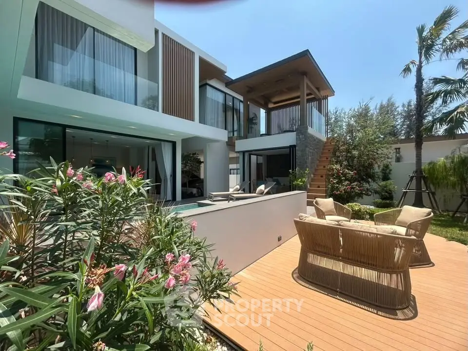 Luxurious modern villa with spacious outdoor deck and lush garden, perfect for relaxation and entertaining.