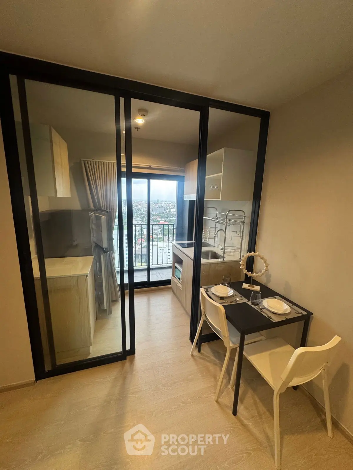 Modern kitchen with balcony view and dining area in stylish apartment