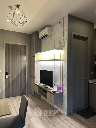Modern living room with stylish decor and wall-mounted TV in a cozy apartment.