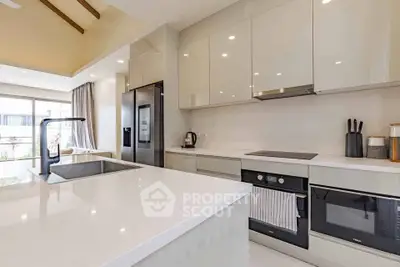 Modern kitchen with sleek white cabinetry and high-end appliances in a bright open layout.