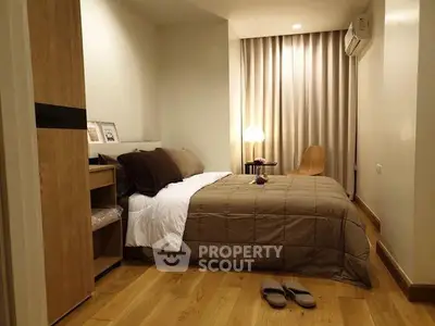 Cozy bedroom with modern decor and warm lighting, featuring a comfortable bed and wooden flooring.