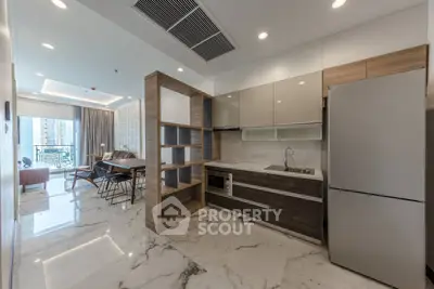 Modern open-layout kitchen with sleek appliances and marble flooring in a stylish apartment.