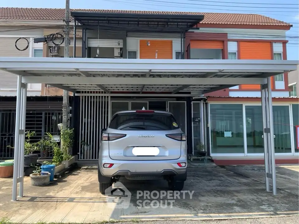 Modern townhouse with carport and sleek exterior design in a suburban neighborhood.