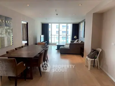 Spacious modern living room with dining area and large windows offering natural light.