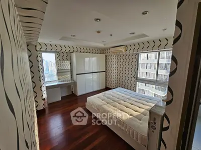 Spacious bedroom with modern design and city view, featuring hardwood floors and ample natural light.