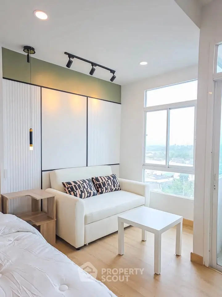 Modern living room with cozy sofa and large windows offering scenic views