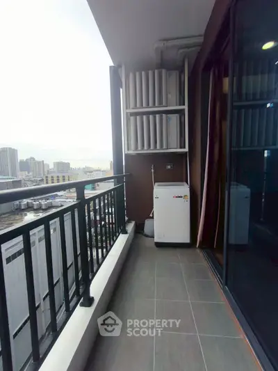 Modern balcony with city view and laundry area in high-rise apartment