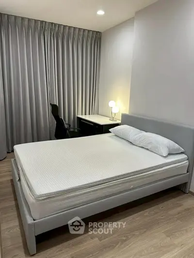 Modern bedroom with sleek design and cozy lighting, featuring a comfortable bed and stylish desk.