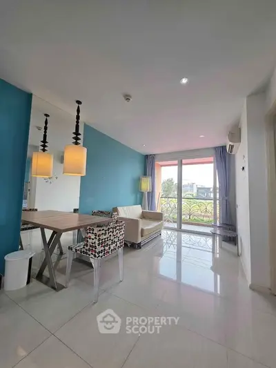 Modern living room with blue accent wall, stylish lighting, and large windows offering natural light.