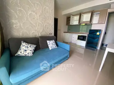 Modern living room with stylish sofa and open kitchen layout in a contemporary apartment.