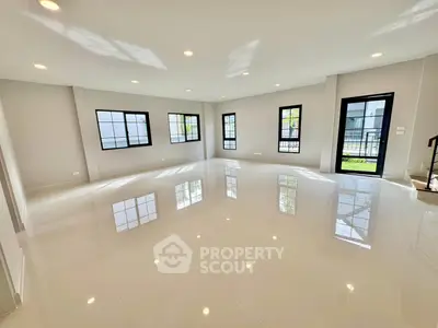 Spacious modern living room with large windows and glossy tiled floor