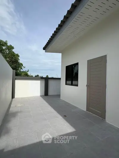 Spacious outdoor terrace with modern design and privacy wall, perfect for relaxation and entertainment.