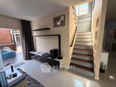 Modern living room with staircase and outdoor pool view