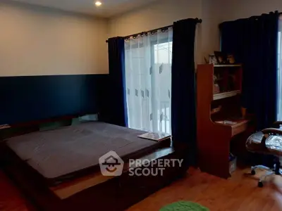 Cozy bedroom with large window and wooden furniture, perfect for relaxation.