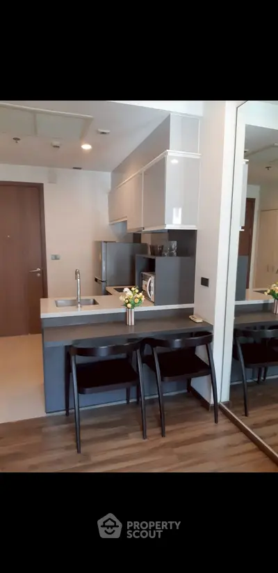 Modern kitchen with sleek cabinetry and breakfast bar in stylish apartment