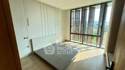 Spacious bedroom with large windows and natural light in modern apartment