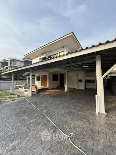 Spacious modern two-story house with large carport and paved driveway