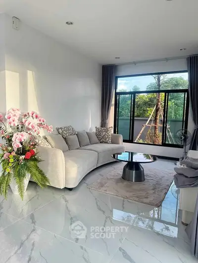 Elegant living room with modern sofa, large window, and stylish decor