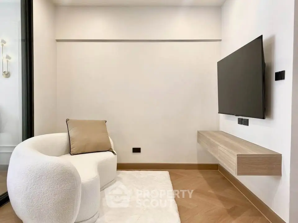 Modern minimalist living room with cozy armchair and wall-mounted TV