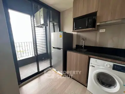Modern kitchen with balcony access, featuring sleek appliances and stylish cabinetry.