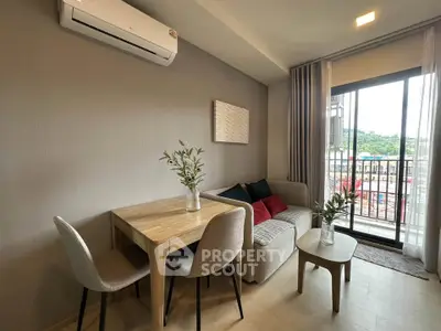 Modern living room with balcony view, featuring cozy seating and dining area.