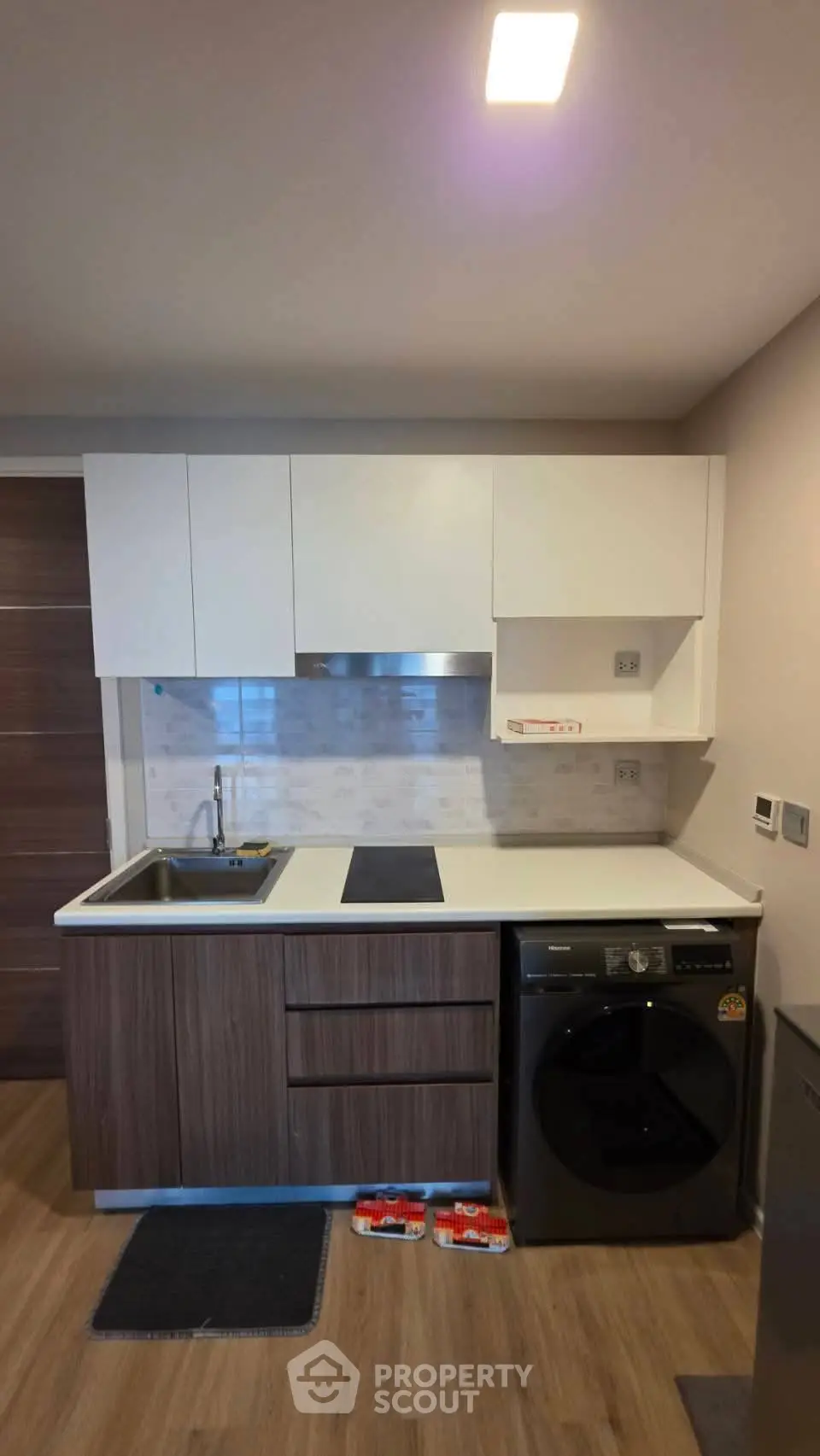 Modern compact kitchen with sleek cabinetry and integrated washing machine