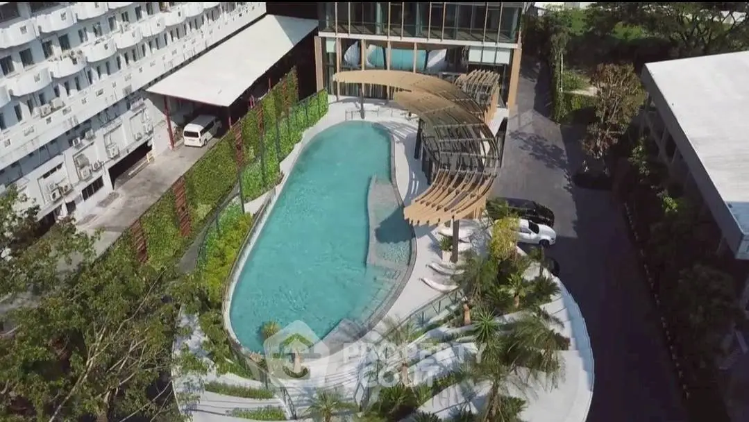 Stunning aerial view of modern residential pool with lush landscaping and elegant design.