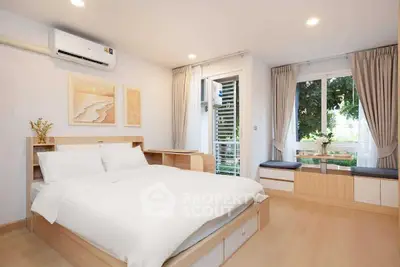 Spacious bedroom with modern decor and large windows for natural light.